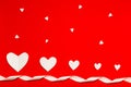White paper hearts with white color ribbon over the red background in flat lay style. Valentine`s Day composition. Holiday concep