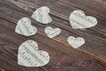 White paper hearts on dark wood.