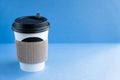 White paper kraft disposable cup for coffee with black plastic lid. coffe to go on blue background Royalty Free Stock Photo