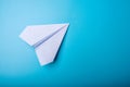 White paper origami airplane lies on pastel blue background Royalty Free Stock Photo