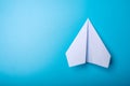 White paper origami airplane lies on pastel blue background Royalty Free Stock Photo