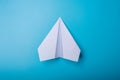 White paper origami airplane lies on pastel blue background Royalty Free Stock Photo