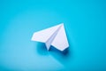 White paper origami airplane lies on pastel blue background Royalty Free Stock Photo