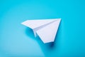 White paper origami airplane lies on pastel blue background Royalty Free Stock Photo