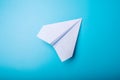 White paper origami airplane lies on pastel blue background Royalty Free Stock Photo