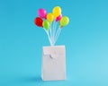 White paper package floating with colorful balloons on blue background Royalty Free Stock Photo