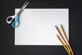 White paper, pencils and scissors on black background Royalty Free Stock Photo