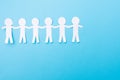 White paper people holding hands. Blue background. Place for text Royalty Free Stock Photo