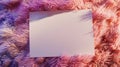 A white paper is placed on top of a pink furry blanket