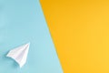 White paper plane on blue and yellow background composition Royalty Free Stock Photo