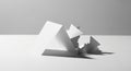 White paper sculptures with sharp geometric shapes and folds sit on a flat surface against a Royalty Free Stock Photo