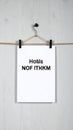 White Paper Sheet Mockup on Clothes Hanger Against a Painted Wall Royalty Free Stock Photo