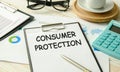 White paper sheet with text CONSUMER PROTECTION on wooden table Royalty Free Stock Photo