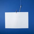 White paper sheet for text and fishing hook with fishing line on blue background. Design element. Close-up, copy space Royalty Free Stock Photo