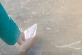 White paper ship is sent on journey into first spring puddle. Child`s hand with origami in sunlight. Early spring mood concept,