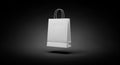 A white paper shopping bag is centrally positioned against a black background. It features two Royalty Free Stock Photo