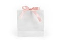 White paper shopping bag with pink bow on white background. Gift box, surprise for holiday. Present, gift, shopping and sale Royalty Free Stock Photo