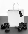 White paper shopping package, black wrapped boxes on black and white. Shopping, Sales. Copy space.