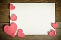 White paper with small pink hearts on a wooden background Royalty Free Stock Photo