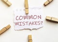 White paper with text Common Mistakes with clothespins on white background Royalty Free Stock Photo