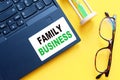 White paper with text FAMILY BUSINESS in male hands on a white background