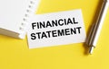 White paper with text Financial statement on a yellow background with stationery Royalty Free Stock Photo