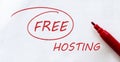 White paper with text Free Hosting on the white with red marker