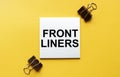 White paper with text Front liners on a yellow background with stationery Royalty Free Stock Photo