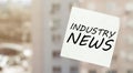 White paper with text Industry News on the window