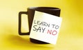 White paper with text Learn To Say No on the black cup Royalty Free Stock Photo