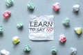 White paper with text Learn To Say No on the blue background with a lot of another paper Royalty Free Stock Photo