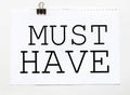 White paper with text Must Have on a white background with stationery Royalty Free Stock Photo