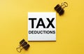 White paper with text Tax Deductions on a yellow background with stationery Royalty Free Stock Photo