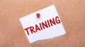 White paper with the text TRAINING is attached to the wooden background with a red button Royalty Free Stock Photo