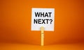White paper with text `Whats next`, clip on wood clothespin. Beautiful orange background. Business concept. Copy space