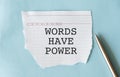 White paper with text Words have power lying on blue background Royalty Free Stock Photo