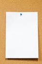 White paper with thumbtack on corkboard