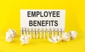 White paper on yellow background with text EMPLOYEE BENEFITS Royalty Free Stock Photo