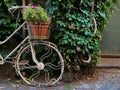 White parked bicycle in city. Bicycle parked next to sidewalk. Bicycle parked next to industrial factory. Italy.