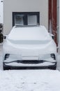 White parked car covered with a thick layer of snow.