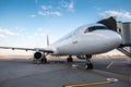 A white passenger airliner at the jetway