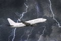 White passenger airplane takes off during a thunderstorm night lightning strike of rain, bad weather. Royalty Free Stock Photo