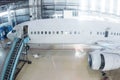 White passenger jetliner in the hangar. Airliner under maintenance