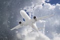 white passenger plane flies through falling snow against backdrop of beautiful ominous clouds on blue sky background in winter