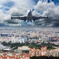 Passenger plane flies above the center of the big city. Front view of aircraft