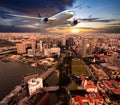 Passenger plane flies above the skyscrapers. Sunset time.