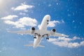 white passenger plane has released its landing gear and is landing through falling snow against background of white clouds and