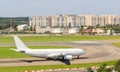 The white passenger plane is moving along the taxiway and getting ready to take off