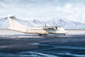 White passenger turboprop airliner on the winter airport apron on the background of high picturesque mountains