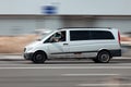White passenger van Mercedes Benz W639 Viano in the city street in motion. Old rusty Mercedes Vito van second generation moving